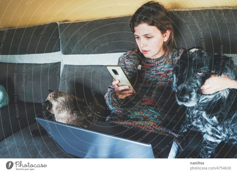 Junge Frau bei der Arbeit zu Hause, umgeben von ihren Haustieren heimwärts Telearbeit Single Hund Katze Laptop freiberuflich Programmierer Entwickler Designer