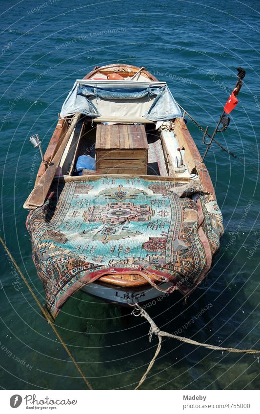 Altes Fischerboot aus Holz im Sommer bei Sonnenschein im Hafen in der Altstadt von Foca in der Provinz Izmir am Ägäischen Meer in der Türkei Heimkehr