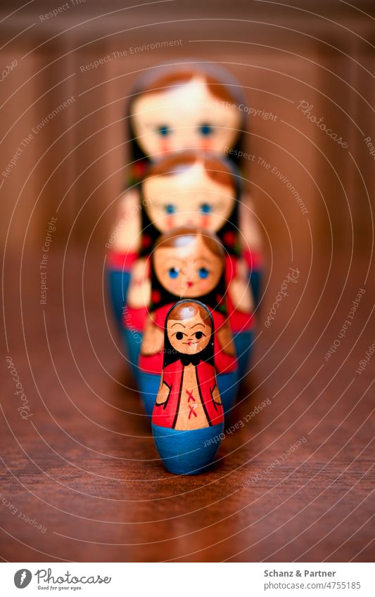 vier russische Matrioschkas auf einem Holztisch Babuschka Russland Spielfiguren Spielzeug Holzspielzeug Russisch Tradition Souvenir
