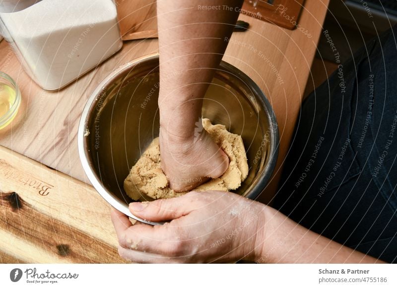 Teig in einer Metallschüssel wird mit der Faust geknetet Backen kneten Schüssel Hände Küche Kuchen Brot Plätzchen backen Mehl Teigwaren Lebensmittel Backwaren
