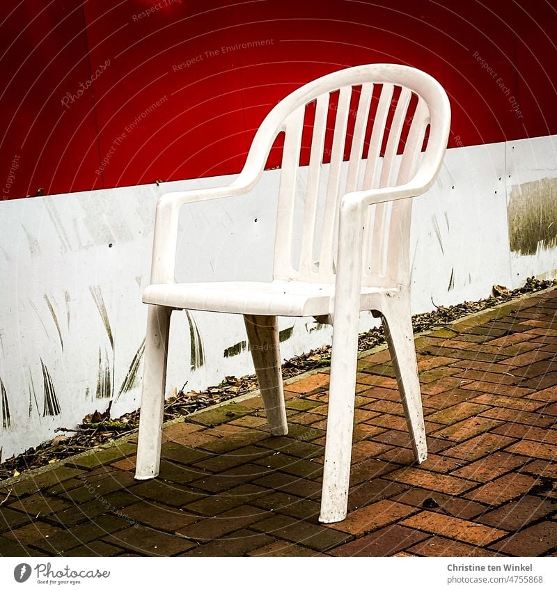 Schmutziger und trister Pausenplatz mit einem weißen Plastikstuhl Stapelstuhl Monoblock Stuhl Gartenstuhl Sitzgelegenheit Kunststoffstuhl Gartenmöbel
