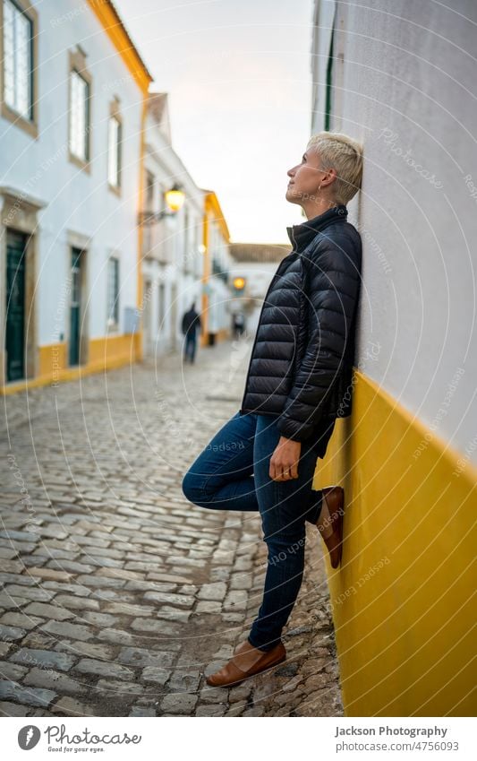 Porträt einer blonden modernen Frau in städtischer Umgebung Großstadt urban Lebensmitte Faro historisch entspannend Stehen Stadtzentrum Gebäude Fröhlichkeit