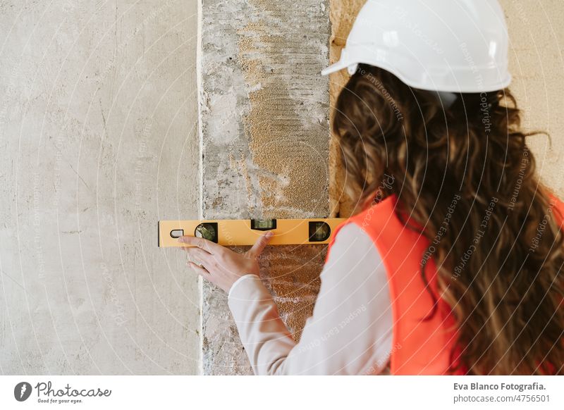 professionelle Architektin Frau in Baustelle mit Ebene Werkzeug an der Wand. Hausrenovierung Niveau Küche Inspektor Überprüfung heimwärts Laptop unkenntlich