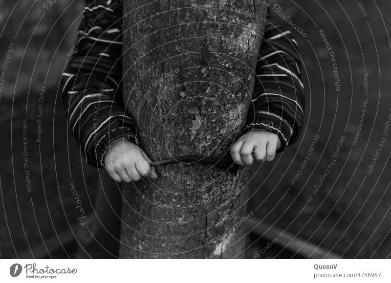 Kind umarmt einen Baum in Schwarzweiß Kindheit umarmen Schwarzweißfoto schwarz Monochrom dunkel Umwelt Umweltschutz Natur Kontrast Pflanze Wald natürlich