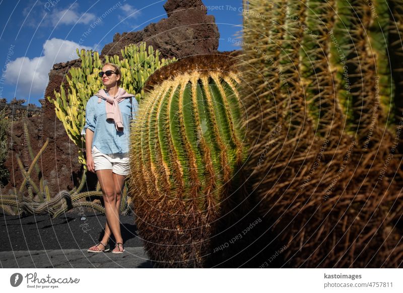 Weibliche Touristin bei der Besichtigung eines tropischen Kaktusgartens im Dorf Guatiza, Lanzarote, Kanarische Inseln, Spanien. Garten Wahrzeichen Frau grün