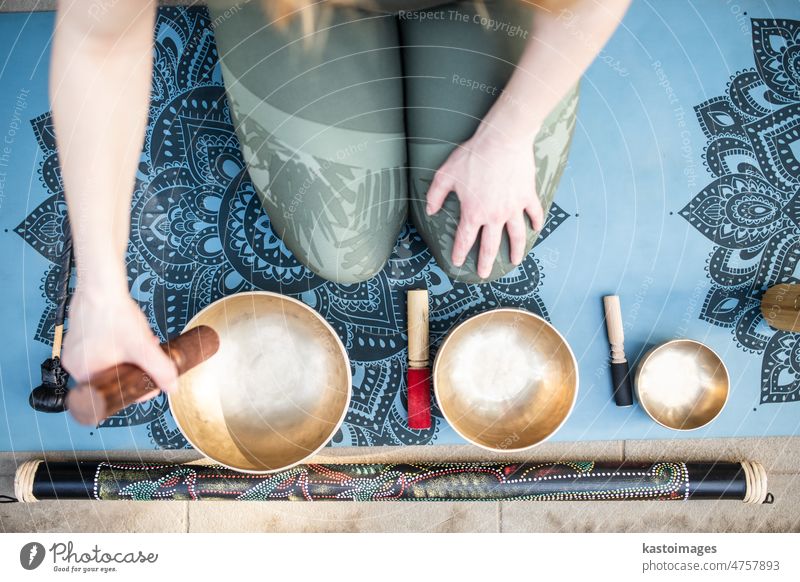 Yoga-Konzept, Meditation und Klangtherapie. Schöne junge kaukasische Frau umgeben von Kupfer tibetischen Klangschalen und Instrumente Therapie