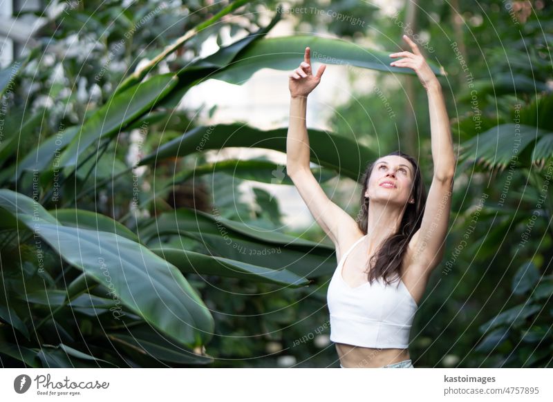Frau meditiert und praktiziert Yoga im tropischen Regenwald. Schöne junge Frau übt Yoga im Freien mit tropischem Wald im Hintergrund Meditation Rückzug Körper