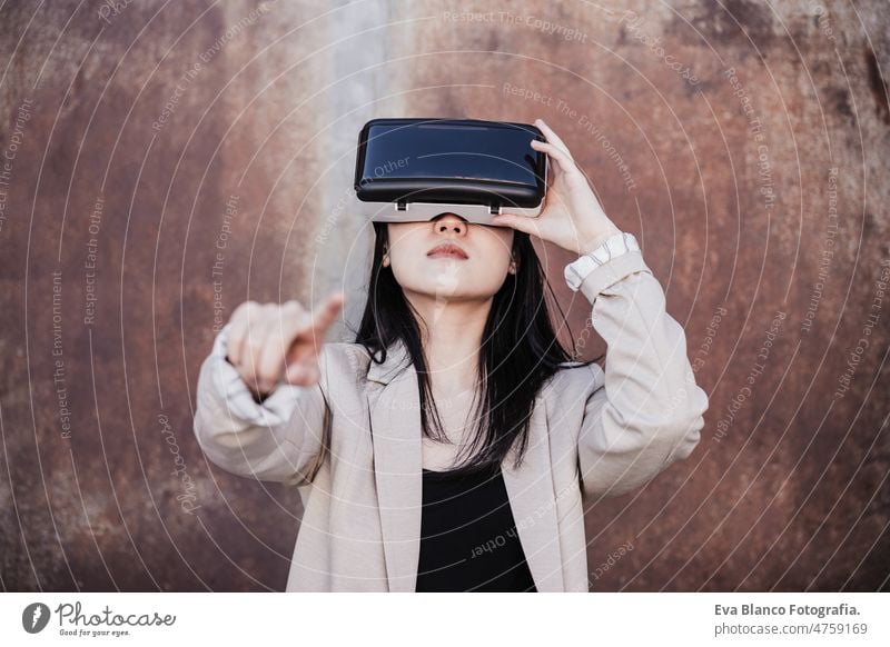 chinesische Geschäftsfrau mit Virtual-Reality-Headset in der Stadt. technologie Chinesisch Frau VR Schutzbrille Metaversum Realität virtuell attraktiv jung