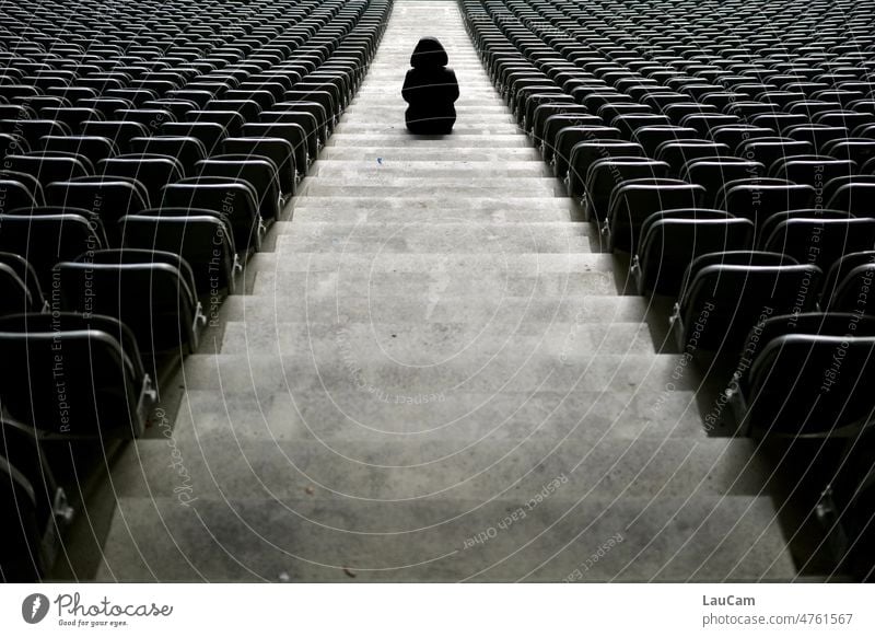 Geisterspiel II - eine einsame Gestalt sitzt noch immer auf der Treppe eines leeren Stadions Stühle Stufen Person Depression allein traurig unheimlich