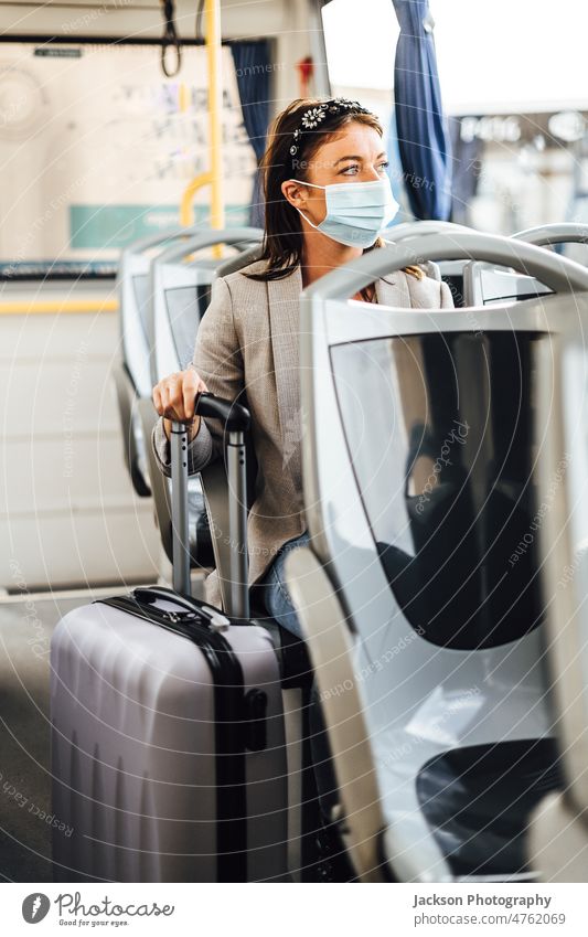 Eine junge Frau mit Maske, die mit dem öffentlichen Bus pendelt Reisender Pandemie Mundschutz Erwachsener Ausflug Auto Fahrzeug lässig Lächeln Laufwerk Sitzen