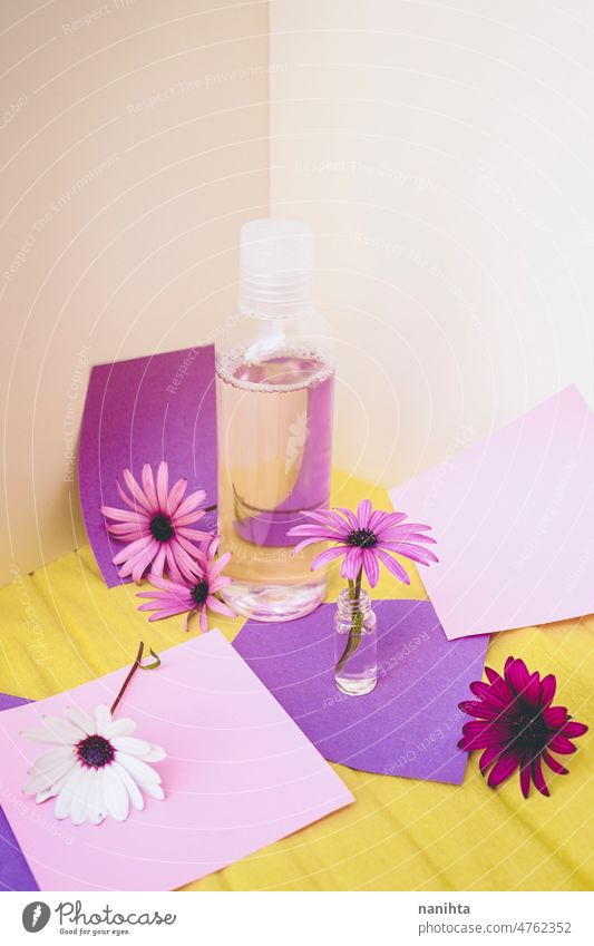Stilleben von Öko-Kosmetik mit Blumen in Papier Hintergrund Design Frühling winzig Flasche Tonic Lotion Duft Wasser geblümt saisonbedingt Pop farbenfroh frisch