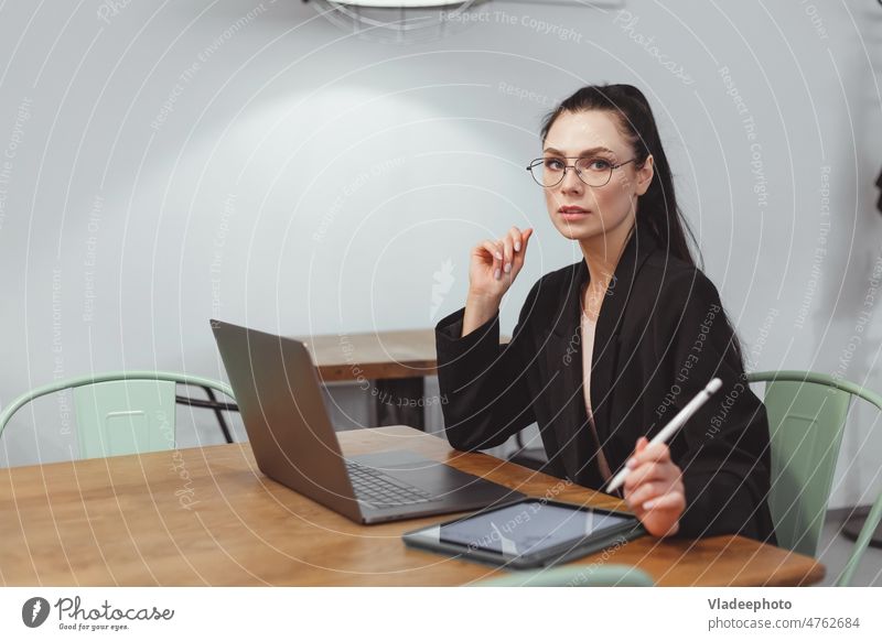 Brünette Geschäftsfrau im schwarzen Anzug arbeitet am Laptop in einem modernen Büro oder Café arbeiten Lifestyle Frau Unternehmer Sitzen Freiberufler Internet