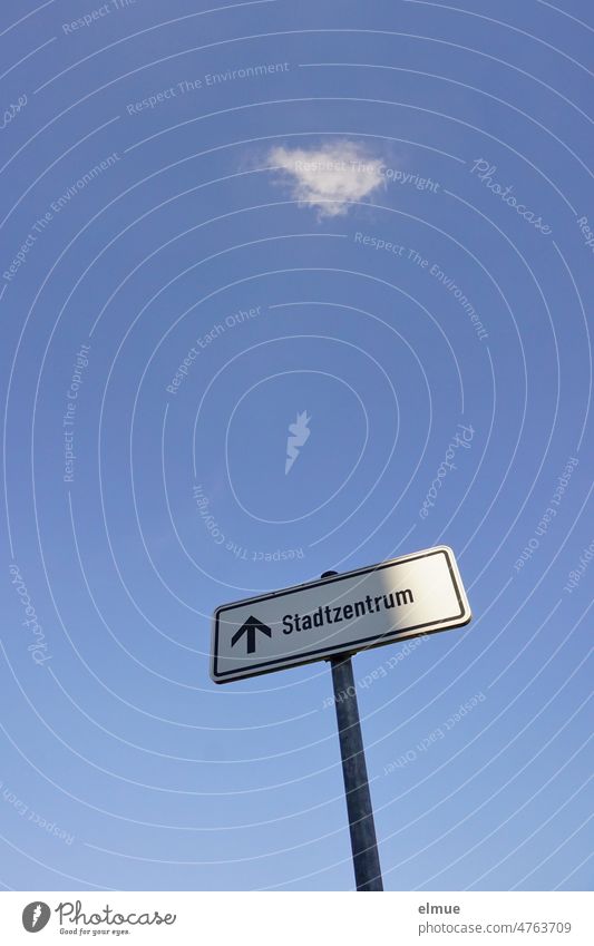 Schild  - Stadtzentrum -  mit Pfeil nach oben an einer Metallstange vor blauem Himmel mit einer einzelnen weißen Wolke aus der Froschperspektive Hinweisschild