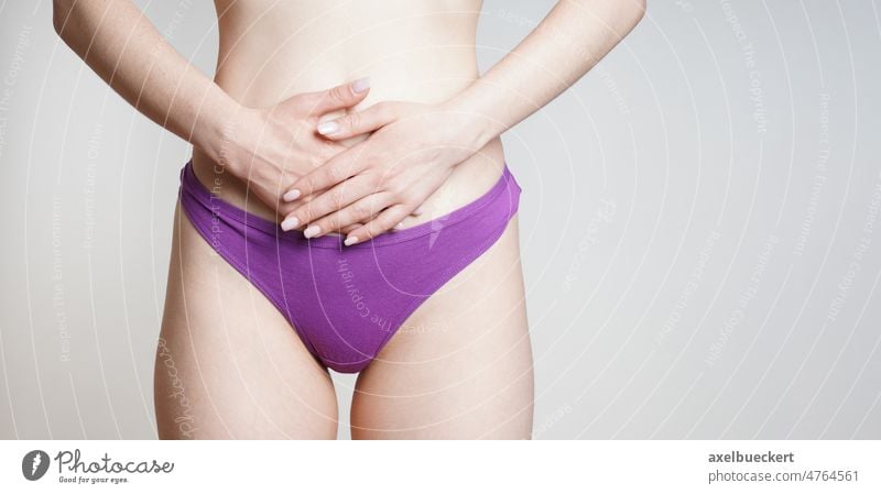 Frau in Unterhose, die sich den Bauch hält, mit Unterleibs- oder Regelschmerzen Gesundheit Beteiligung Schmerzen abdominal Zeitraum Endometriose menstruell