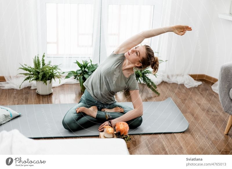 Schöne junge Frau macht Übungen und macht Yoga zu Hause heimwärts praktizieren Körper Lifestyle Fitness Training Meditation Unterlage Sport sportlich
