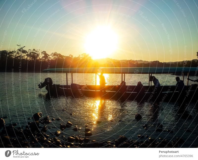 Silhouette von Menschen in einem Boot auf dem Fluss bei Sonnenuntergang. gelb Mann Floß Baum Wasser Sommer Natur Berge u. Gebirge reisen schön im Freien