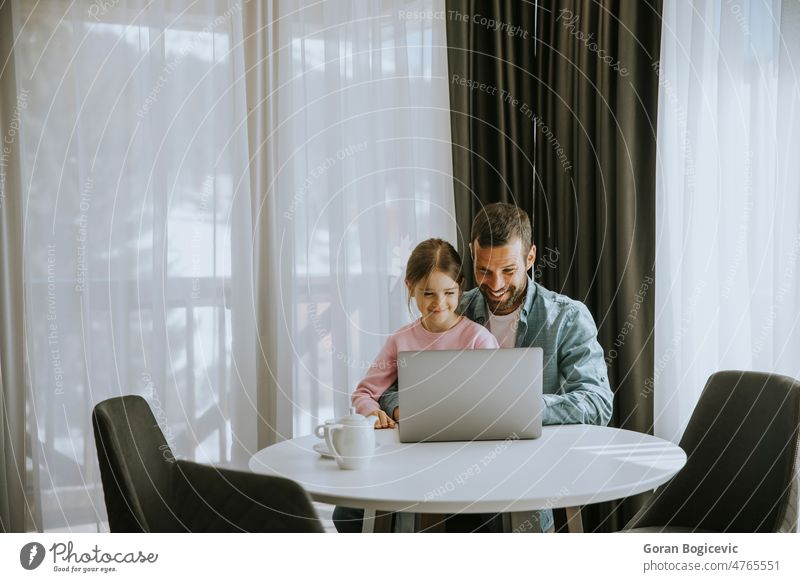 Vater und Tochter benutzen gemeinsam einen Laptop Mann Zusammensein Lächeln Mädchen Papa Computer Technik & Technologie heimwärts Kind Familie Eltern jung Glück
