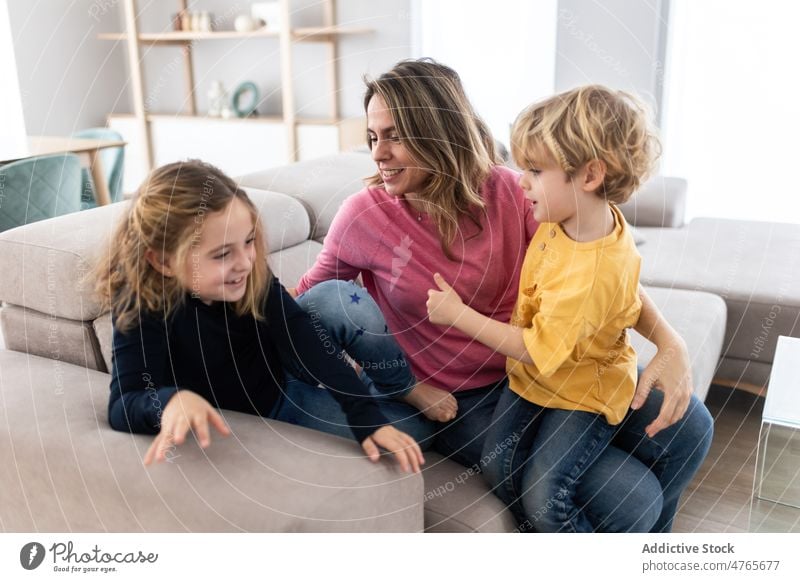 Mutter umarmt Sohn in der Nähe der Tochter Kinder Geschwisterkind Zeitvertreib Zeit verbringen Wohnzimmer Umarmung Liebe Kindheit kuscheln Streicheln Umarmen