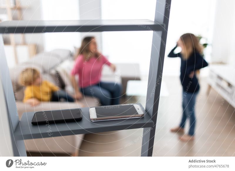 Smartphones auf der Leiter im Zimmer einer Mutter mit Kindern Wohnzimmer Kindheit Zeit verbringen digitale Entgiftung Zeitvertreib Abstinenz Verbindungsabbruch