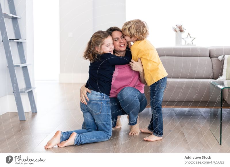 Kinder küssen Mutter im Wohnzimmer Geschwisterkind Zeitvertreib Zeit verbringen Liebe Kindheit Kuss Streicheln Umarmung Umarmen Mutterschaft Bonden Zusammensein