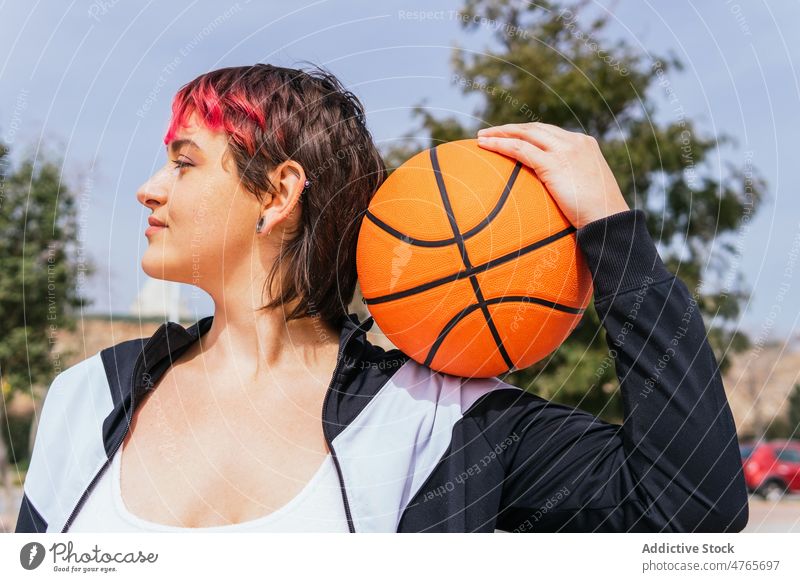 Weiblicher Basketballspieler mit Ball auf Sportplatz Sportlerin Spieler Streetball Reifen spielen Sportpark Tor Frau Himmel Sommer Baum Hobby üben Training