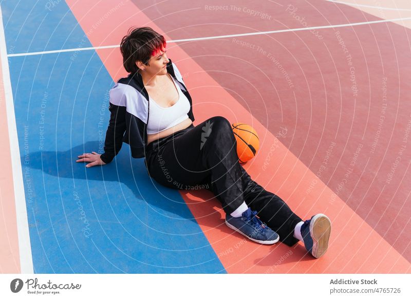 Sportlerin liegend auf Sportplatz in der Nähe von Basketball Spieler Streetball Pause Ball Sportpark ruhen Lügen Frau Hobby üben Training Aktivität Lifestyle