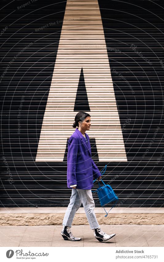 Stilvolle Frau in der Nähe eines Gebäudes auf der Straße Großstadt trendy Mode Fensterladen urban Spaziergang Vorschein Wand Gate feminin Mantel Kleidung Stoff