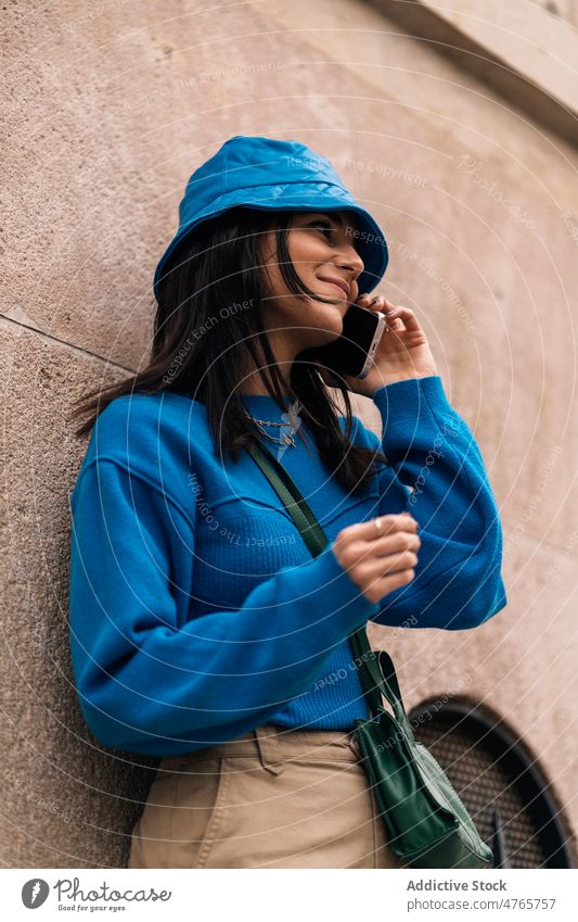 Frau spricht mit Smartphone in der Stadt Telefonanruf Gespräch Straße Streetstyle Großstadt urban Talkrunde Kommunizieren Fußweg Vorschein Dame attraktiv Licht