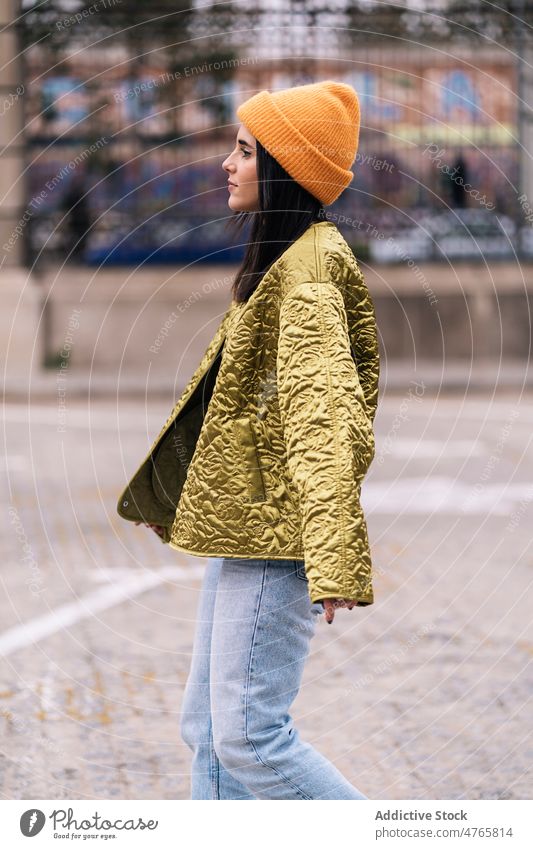 Positive Frau in Mantel und Mütze auf der Straße Stil Großstadt Outfit trendy Mode urban Vorschein feminin Glück Hut stylisch Kopfbedeckung positiv Kleidung
