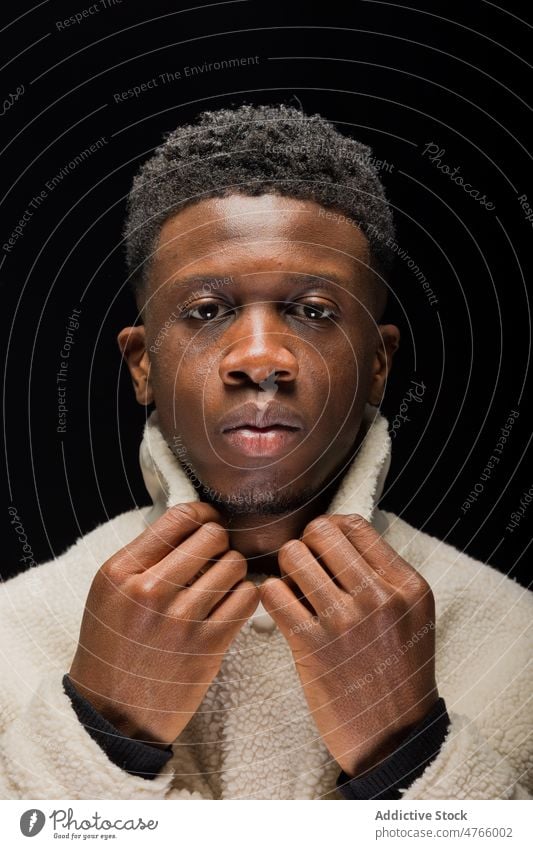Afroamerikanischer Mann in warmer Strickjacke Model Persönlichkeit Individualität Stil Atelier Kragen Vorschein Porträt selbstbewusst männlich Windstille ernst