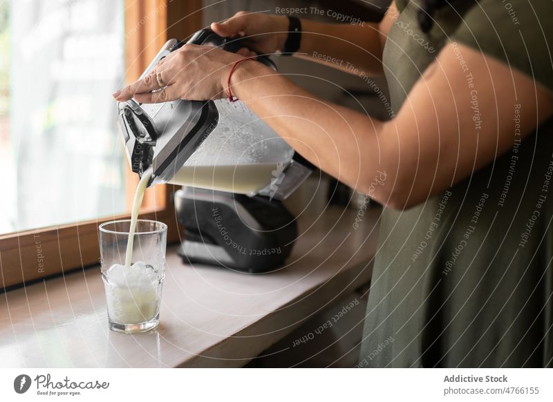 Unbekannte Frau gießt Smoothie in ein Glas Salatgurke Küche Vorrichtung Entzug gesundes Getränk Erfrischung Antioxidans trinken Gerät Abfertigungsschalter
