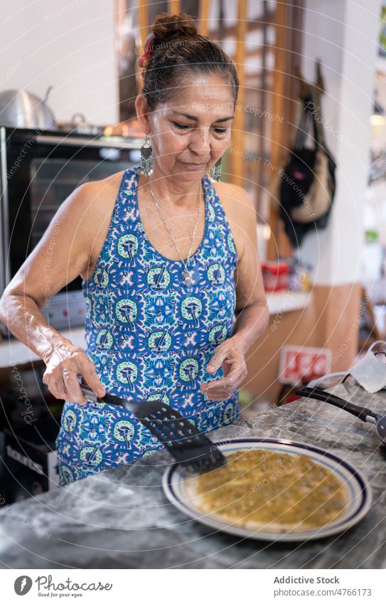 Mexikanische Frau bestreicht Tortilla mit Soße mexikanisches Essen Saucen Koch Speise kulinarisch Mahlzeit Küche hispanisch ethnisch gemischte Rasse
