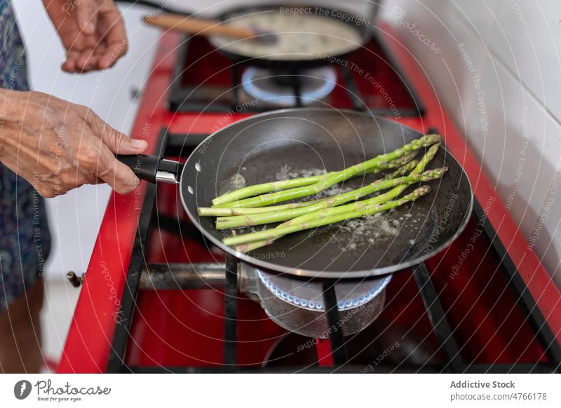 Unbekannter Koch brät Spargel in der Küche Küchenchef braten kulinarisch Lebensmittel Rezept Herd frisch vorbereiten mexikanisch Prozess Fokus Gastronomie