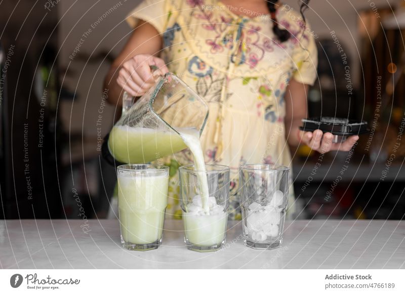 Unbekannte Frau gießt Smoothies in ein Glas Salatgurke Küche Vorrichtung Entzug gesundes Getränk Erfrischung Antioxidans trinken Gerät Abfertigungsschalter