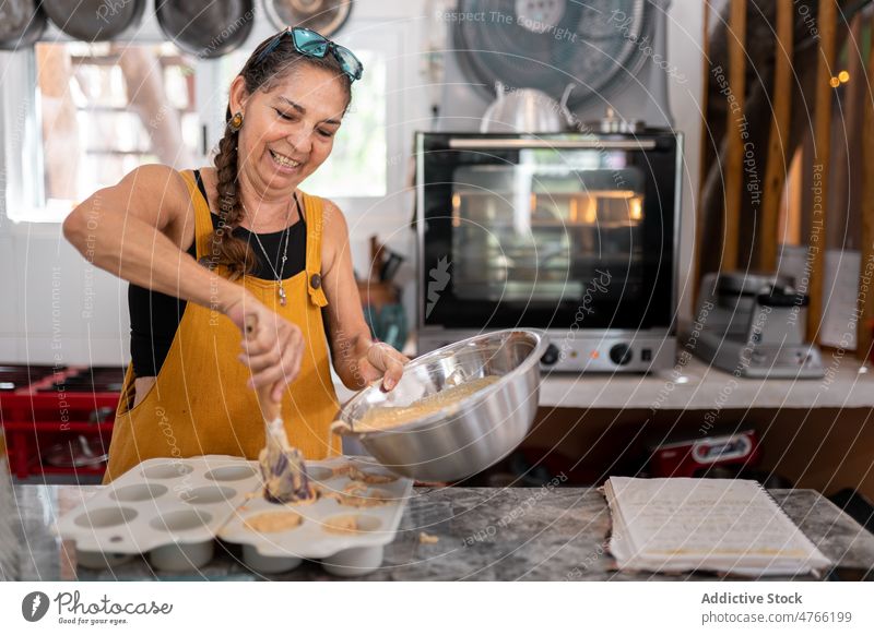 Mexikanische Frau gibt Muffinteig in eine Backform mexikanisches Essen Küche Cupcake Teig Dessert Bäckerei Koch kulinarisch Backblech hispanisch ethnisch