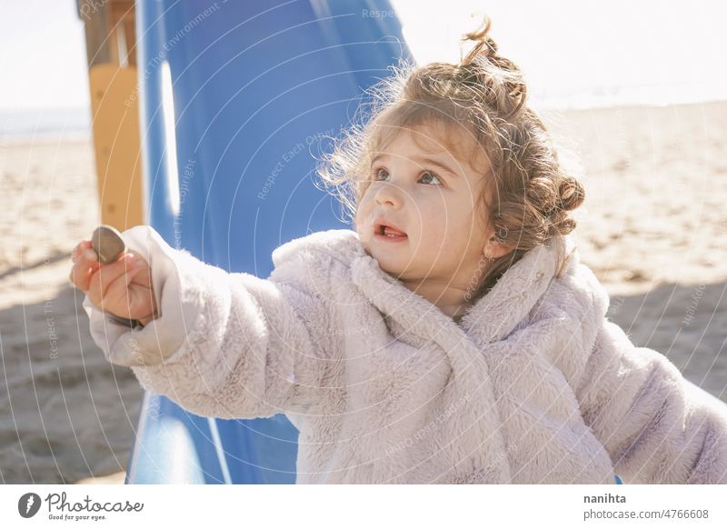 Kleines Mädchen gibt ihrem Vater auf dem Spielplatz einen Stein Kleinkind geben Geschenk teilen Gesicht lieblich niedlich Sliden lockig Behaarung Fell Mantel