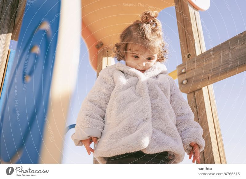 Kleines Mädchen genießt einen sonnigen Wintertag auf dem Spielplatz Kleinkind Glück neugierig spielerisch erkunden Strand Familie Sonne bezaubernd lieblich