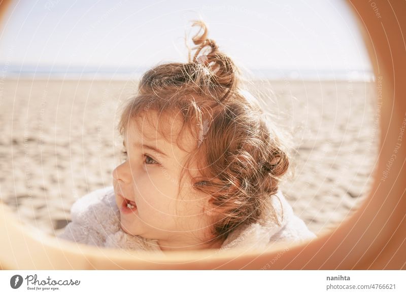 Porträt eines kleinen Mädchens an einem sonnigen Wintertag spielerisch Baby im Freien lockig Strand bezaubernd niedlich Behaarung lieblich Kleinkind Europäer