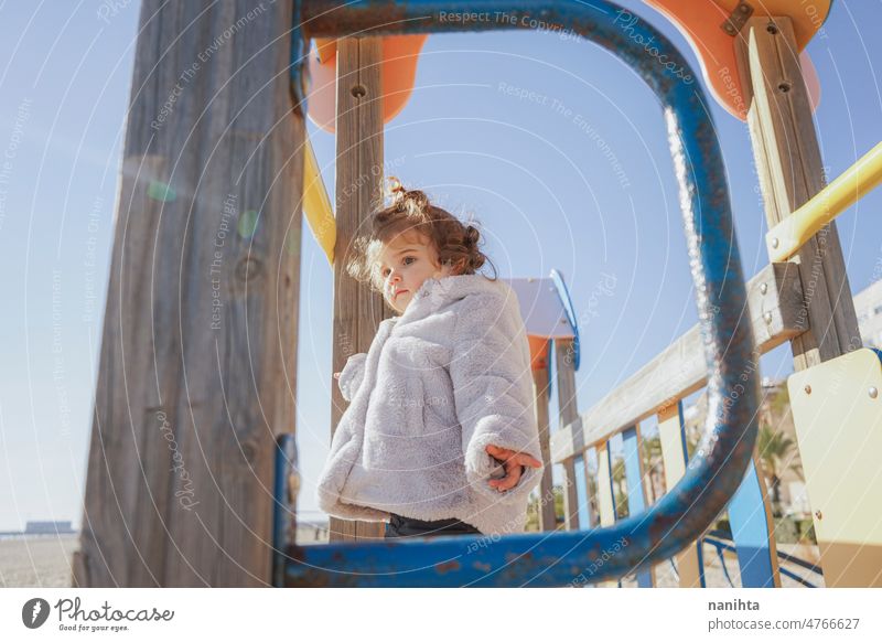 Kleines Mädchen genießt einen sonnigen Wintertag auf dem Spielplatz am Strand Kleinkind Glück neugierig spielerisch erkunden Familie Sonne bezaubernd lieblich