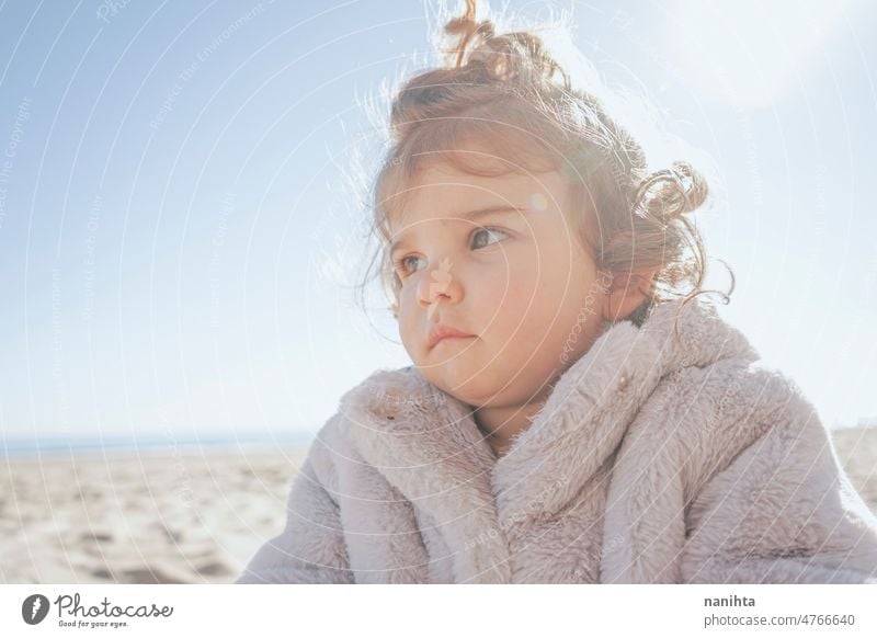 Porträt eines kleinen Mädchens an einem sonnigen Wintertag spielerisch Baby im Freien lockig Strand bezaubernd niedlich Behaarung lieblich Kleinkind Europäer