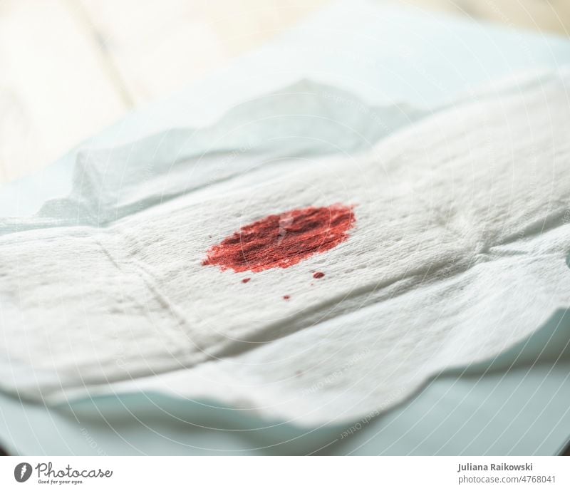 Damenbinde mit Blutfleck rot weiß Nahaufnahme Schmerz Periode Menstruation Gesundheit Zyklus Tampon feminin Frau menstruell Gesundheitswesen Pflege Medizin