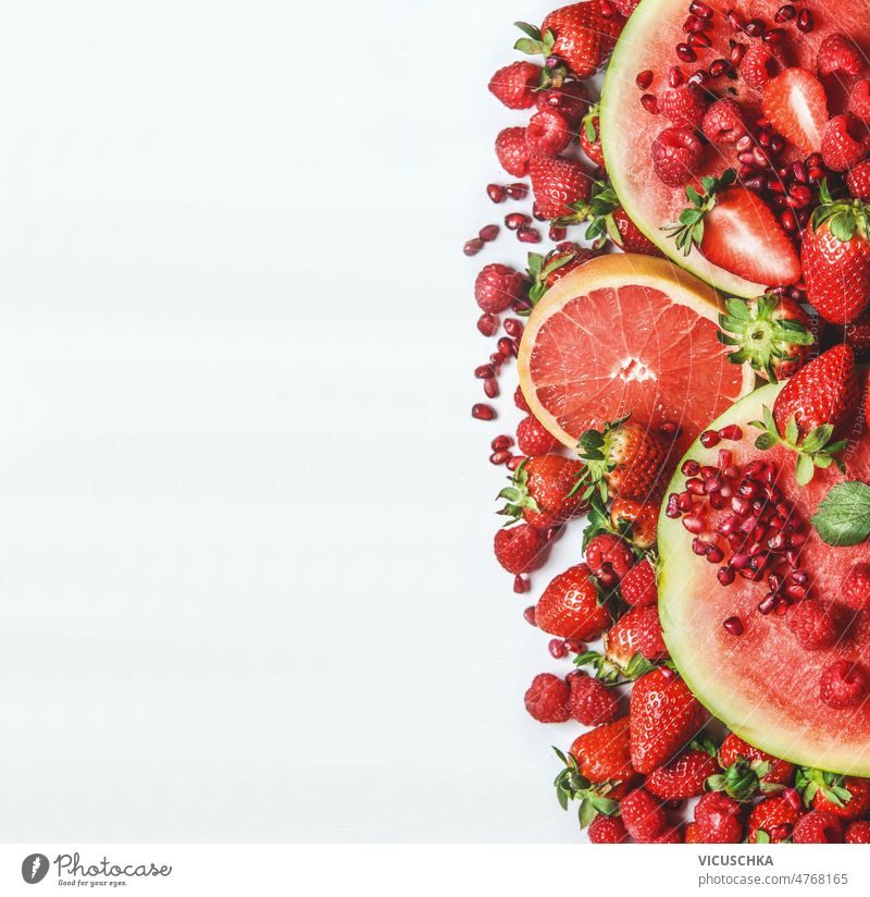 Rote Früchte und Beeren auf weißem Hintergrund. Wassermelone, Grapefruit, Erdbeeren, Himbeeren und Granatapfelkerne rot weißer Hintergrund erdbeeren Gesundheit