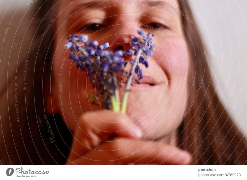 Eine Frau hält einen kleinen selbstgepflückten Blumenstrauß und schnuppert daran. Natürlichkeit, Wellness, Freude. Gut riechen blumen wiesenblumen lila