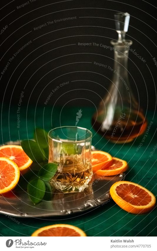 Szene mit Whiskeyglas, Orangen, Dekanter und jadegrünem Hintergrund Lebensmittel trinken Getränk Alkohol Cocktail orange Karaffen Glas altehrwürdig elegant