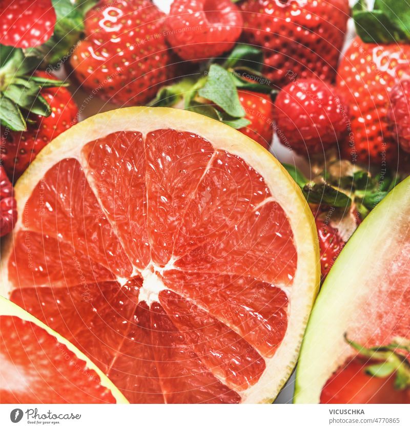 Nahaufnahme einer roten Grapefruithälfte und Erdbeeren. Früchte Hintergrund abschließen Hälfte erdbeeren fruchtig saftig Gesundheit erfrischend Sommer lecker