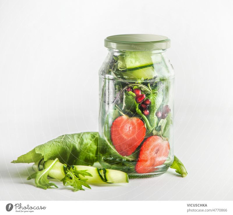 Salat im Glas mit grünen Salatblättern, Erdbeeren, Gurken und Granatapfelkernen. Salatbeilage gesunde Ernährung Mittagessen zum Mitnehmen erdbeeren Salatgurke