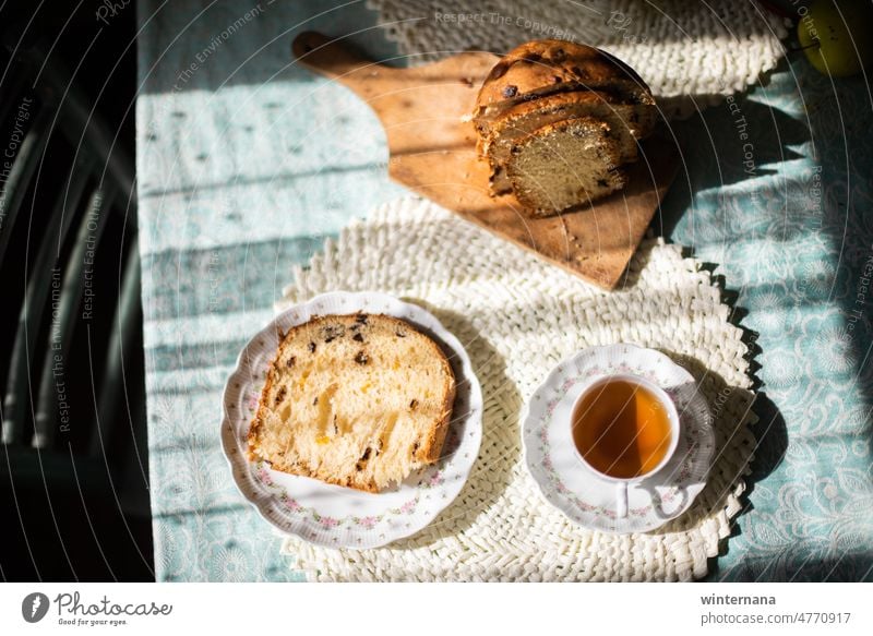 Schöner Tisch mit schönem Porzellan, Tasse Tee, und Scheiben von Osterbraten heiß warm Ostern Brot Gerichte Punkte Sonne Stuhl weiß grün Licht Schatten Freude