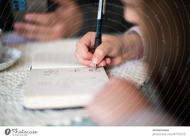 Die Kinder schreiben, der Vater schaut auf sein Telefon, Tisch Auslosung schreibend Schreibstift Hände zuschauend heimwärts Bildung Menschen studierend jung