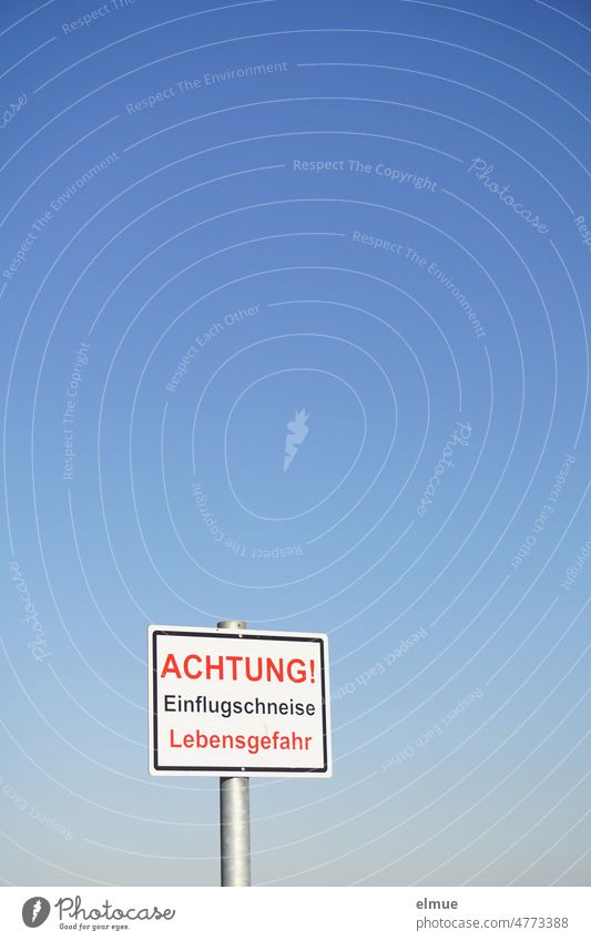 Schild mit der Aufschrift - ACHTUNG! Einflugschneise  Lebensgefahr -  vor blauem Himmel / Flugverkehr Achtung Hinweis Hinweisschild Flugplatz himmelblau