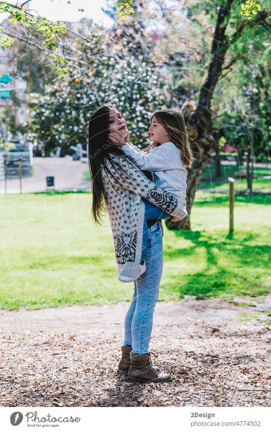 Kleine niedliche Kind Baby umarmt Mama, umarmen mit glücklichen hübsche Frau in grünen Park. Umarmen Umarmung Kuss Eltern Zusammensein Tochter Fröhlichkeit